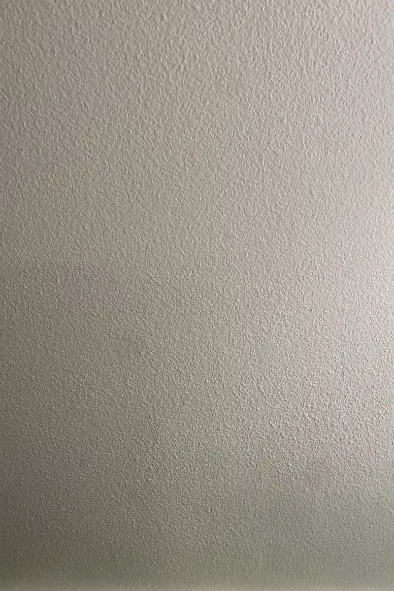 Hole patched and skimmed drywall in Aliso Viejo, smooth flat wall with no visible seams and even natural light reflection.