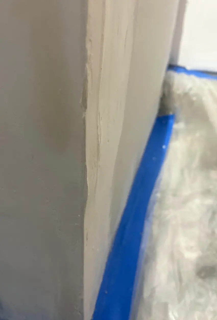 Drywall hole patched and skimmed smooth, wall blends evenly with no visible seams or shadows in natural light.