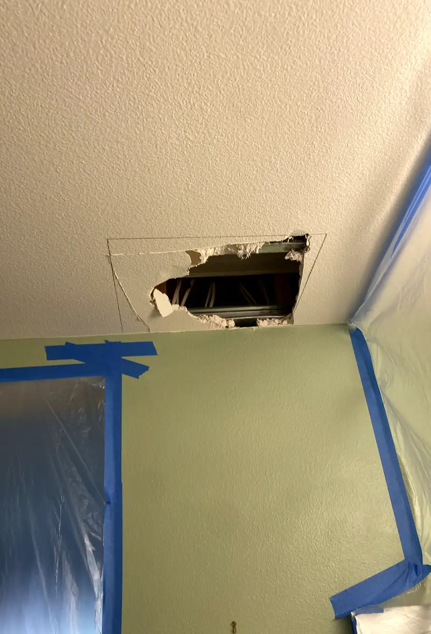 Patched hole in drywall, surface skimmed smooth and blended with surrounding wall, even finish without shadows or seams.