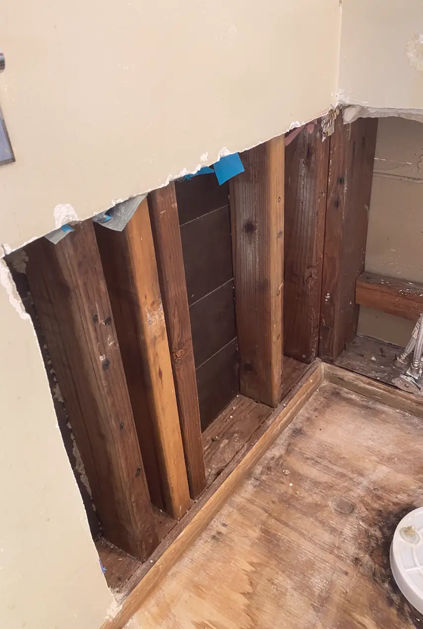 Repaired drywall patch filling a large hole, surface smoothed and blended with surrounding wall, no visible seams or shadows.