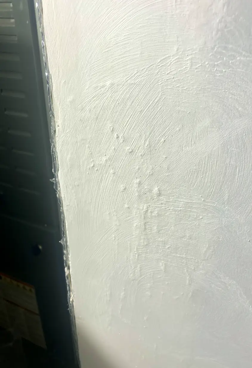 Repaired drywall hole patched and blended smoothly with surrounding wall; surface is flat with no visible seams or shadows.