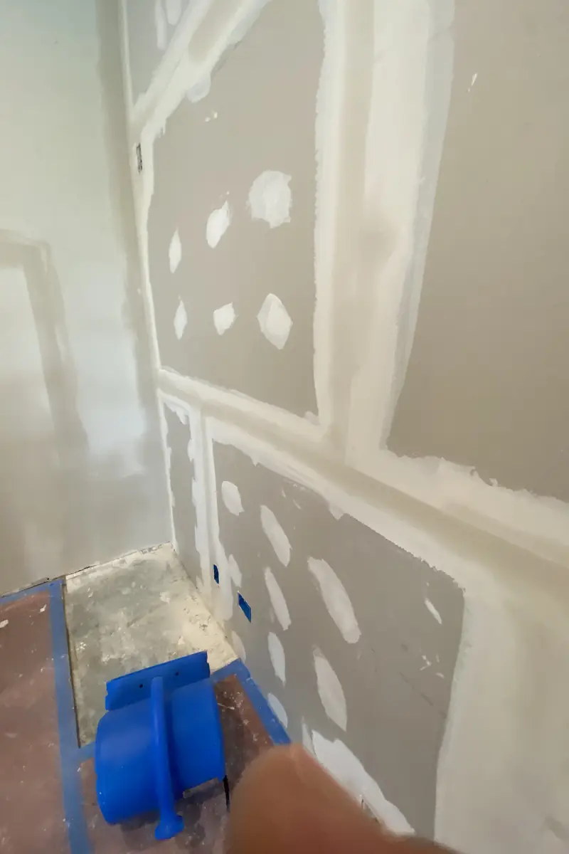 Large hole in drywall patched and skimmed smooth, wall surface blended flawlessly with no visible seams or shadows.