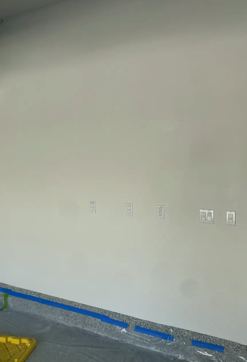 Patched hole in drywall, surface rebuilt and skimmed smooth with blended edges, wall now flat with no visible seams.