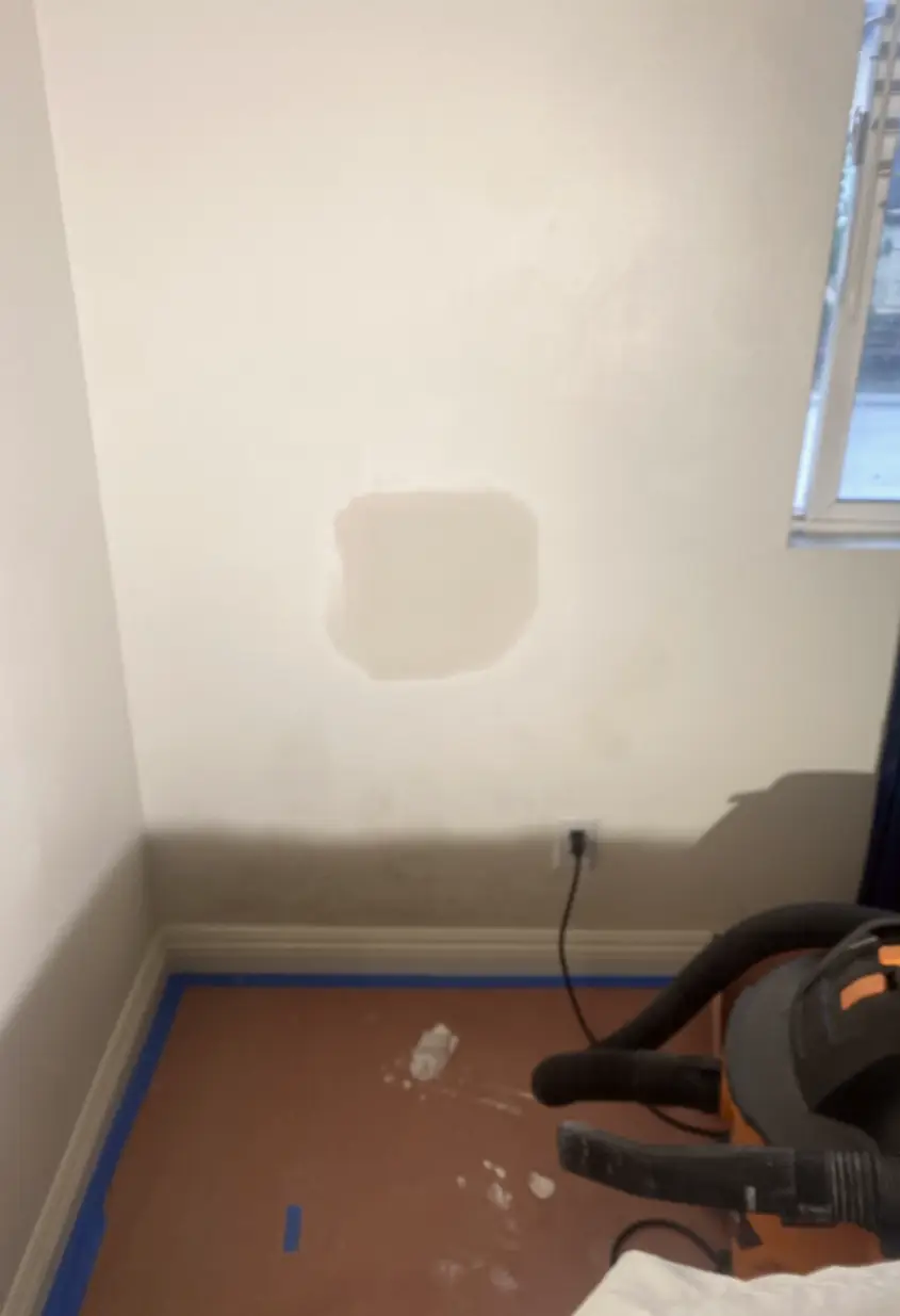 Patched drywall hole in La Palma, surface rebuilt and skimmed smooth with no visible seams or shadows across the wall.