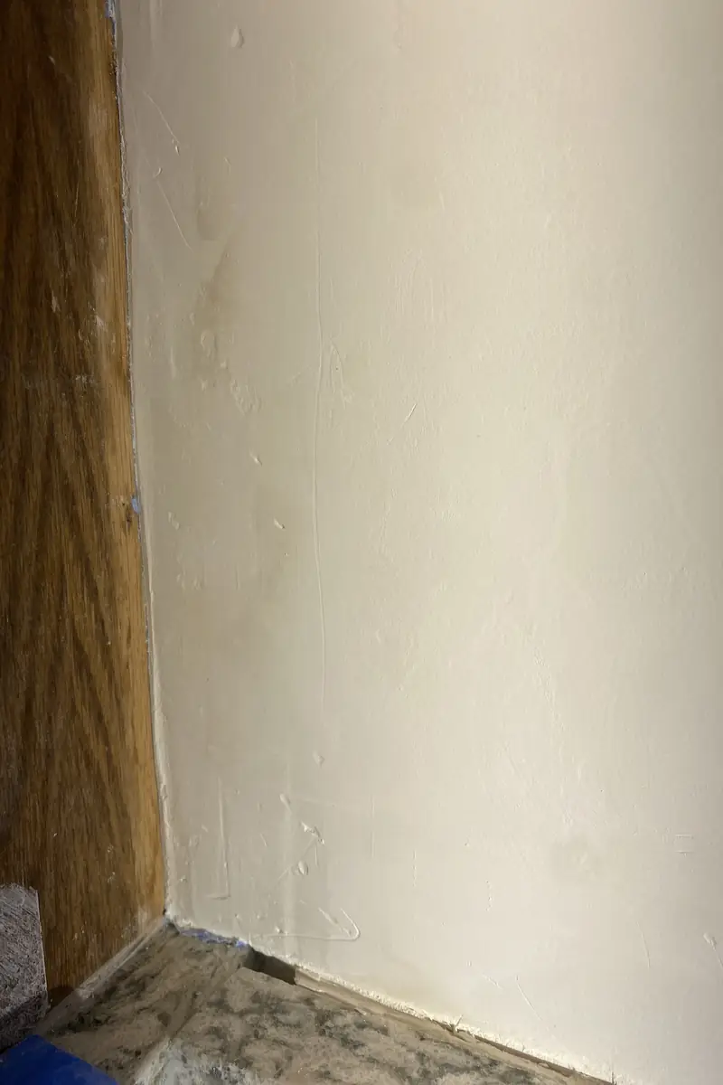 Repaired wall with a previously large hole now smoothly patched and blended with no visible seams or shadows.