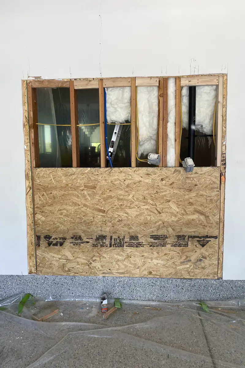 Repaired drywall with a patched hole now smooth and blended, showing a flat surface free of cracks or shadows.