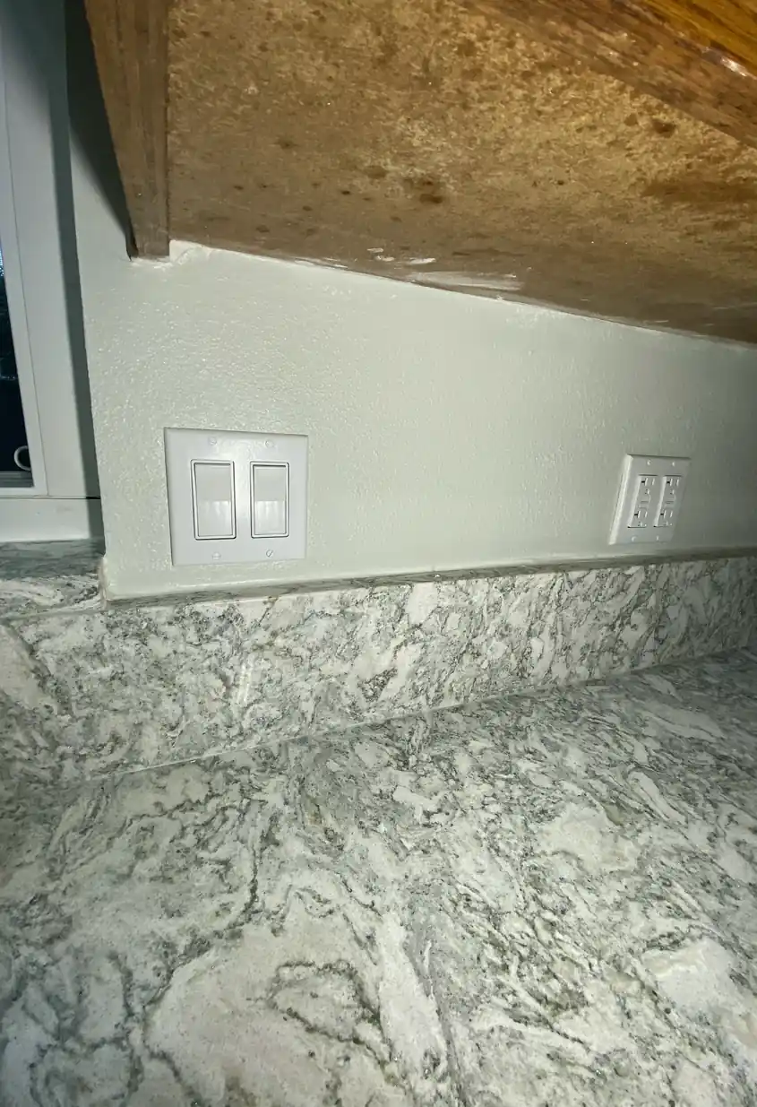 Repaired drywall with a patched hole, surface skimmed and blended smoothly with surrounding wall in natural light, no visible seams.