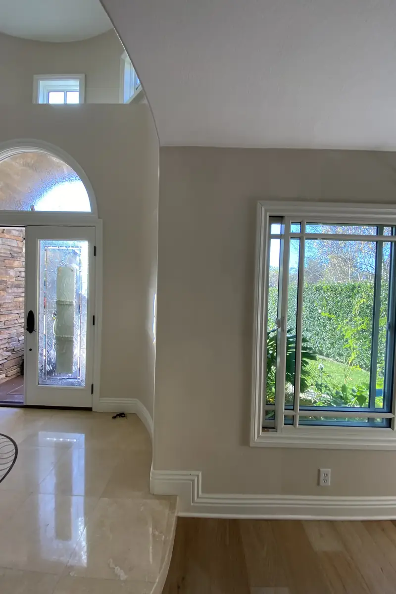 Repaired drywall patch where a medium hole was rebuilt and skimmed to a smooth, flat surface with no visible seams or shadows.