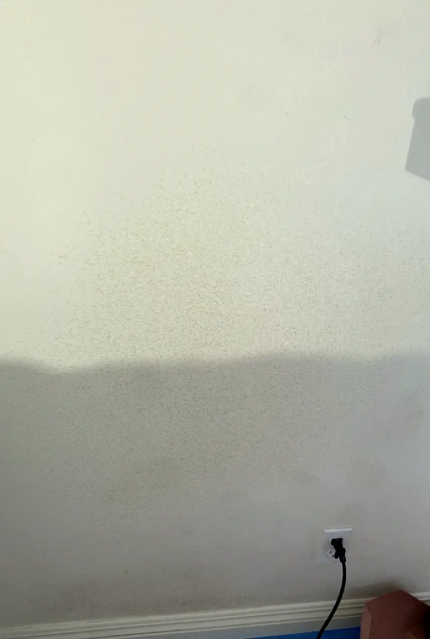 Hole in drywall patched and blended smoothly, wall surface flat and even with no visible seams or shadows.