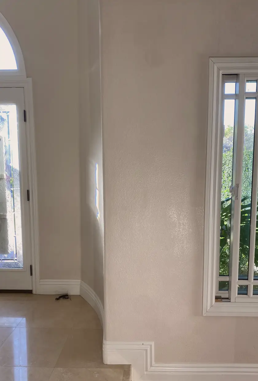 Patched drywall hole now a smooth, even surface with no visible seams or shadows from natural light in Orange home.