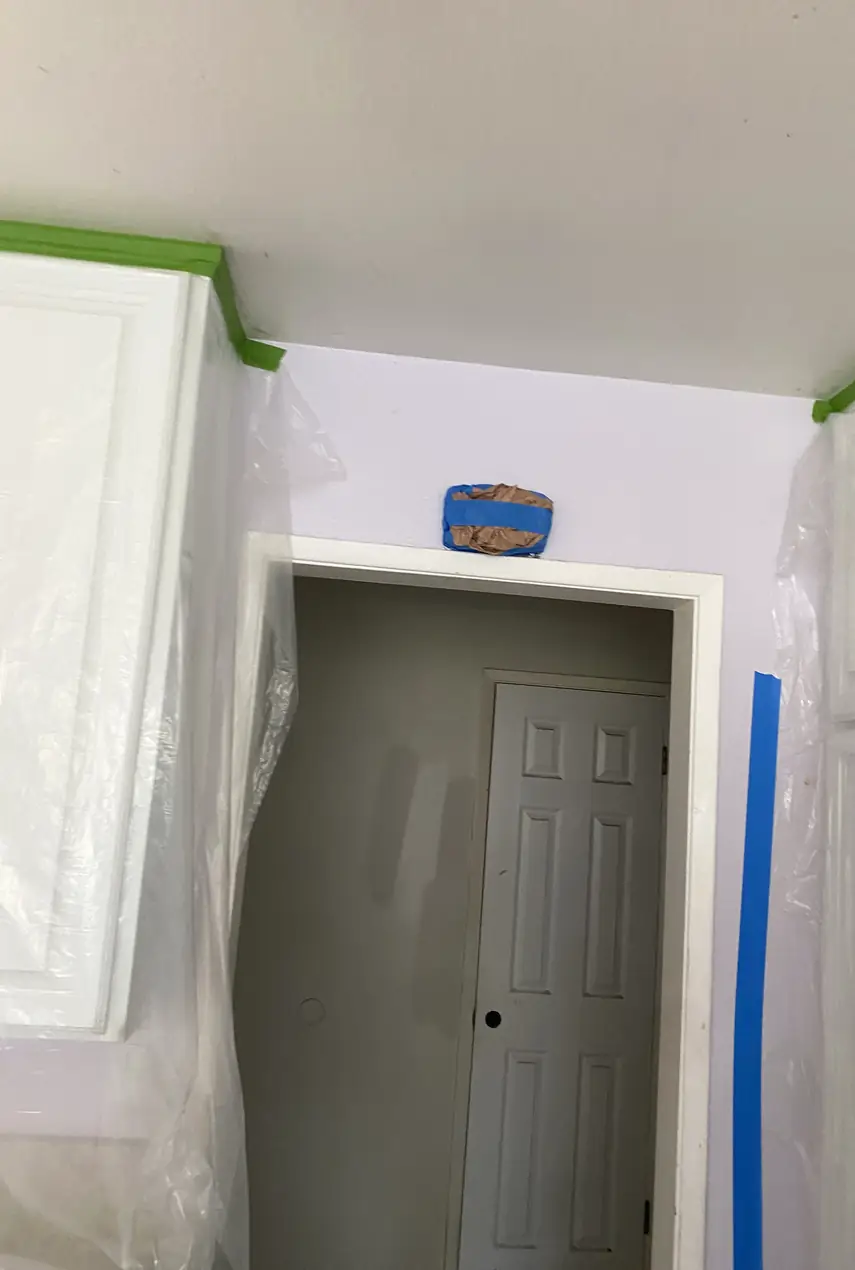 Small wall hole patched and skimmed smooth, final surface blends evenly with surrounding drywall, no visible seams or shadows.