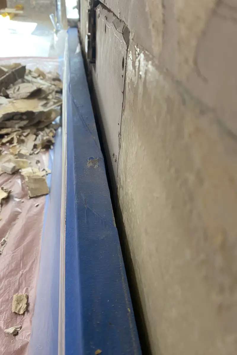 Repaired drywall patch in living room wall, surface rebuilt flat and smoothly blended with no visible seams or shadows